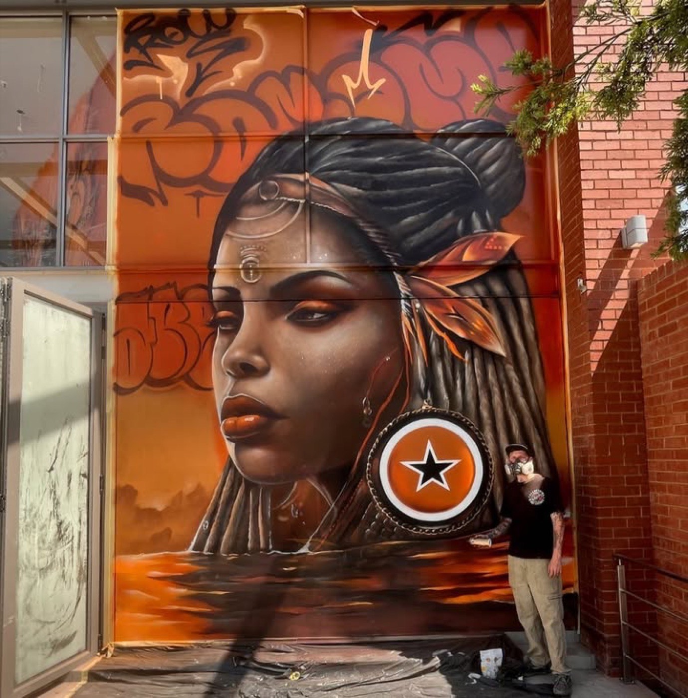 Vivid orange portrait mural with traditional jewellery by Top Murals
